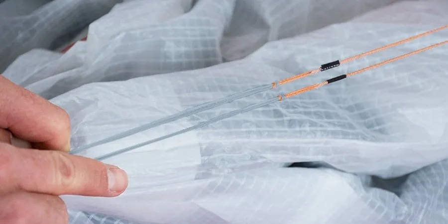 Hand an einem reparierten Kite-Tuch mit neuer Naht