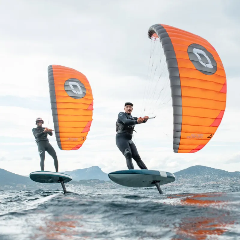 Zwei Parawing-Foiler mit orangefarbenen Schirmen auf dem Wasser